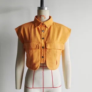 Detail shot of an orange sleeveless denim vest with polo collar and large pockets