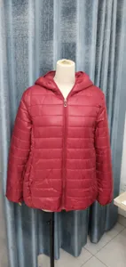 Detail view of a women's red lightweight hooded padded jacket displayed on a white mannequin