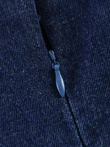 Détail en gros plan montrant la fermeture éclair invisible et la texture du haut en denim