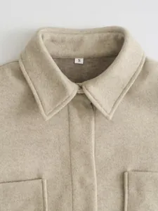 Nahaufnahme von Kragen und Wolltextur eines beigen Oversized-Wollhemdes für Damen
