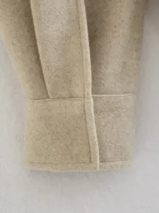 Detailaufnahme einer beigen Wollmantelmanschette zeigt Nähte und die Stoffstruktur.