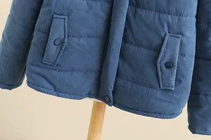 Detail view of blue quilted puffer jacket featuring side pockets and snap buttons