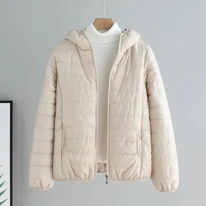 Women's minimalist light beige hooded puffer jacket with quilted design on wooden hanger