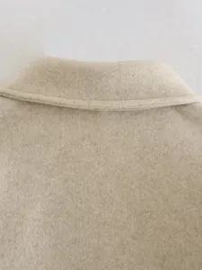 Detaillierte Nahaufnahme von Kragen und Textur eines beigen Wollmantels für Damen
