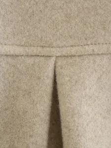 Detailaufnahme der weichen beige Wollmantel Stoffstruktur und hochwertigen Verarbeitun