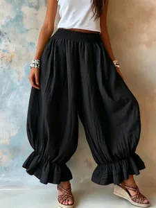 Detailed view of black cotton-linen harem pants featuring ruffled hem and elastic waist