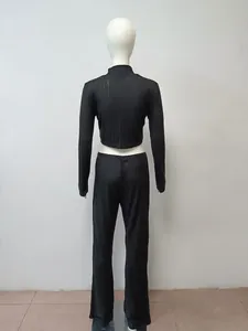 Vista posteriore di un set in maglia nera a due pezzi con crop top e pantaloni a vita alta