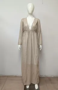 Full length view of a sparkly apricot V-neck maxi dress with long sleeves on a mannequin.