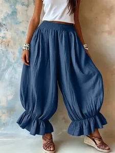 Detail of loose blue cotton linen harem pants with elegant ruffle hem for summer