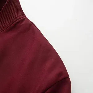 Λεπτομερές κοντινό πλάνο μπορντό μπουφάν που δείχνει τον όρθιο γιακά και την υφή του ώμου
