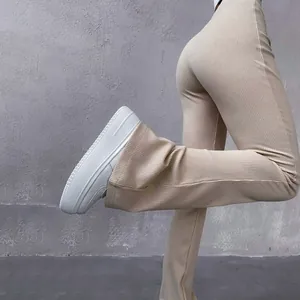 Close-up detail of high waisted ribbed flare pants in beige showing slim fit and texture