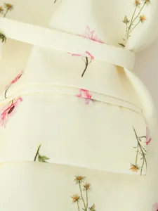Vue macro détaillée du tissu à imprimé floral et de la ceinture sur un blazer femme