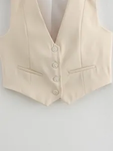 Detailed macro view of cream women's V-neck waistcoat featuring four buttons and welt pockets