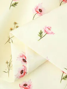 Gros plan sur l'imprimé floral rose d'un tissu de blazer crème