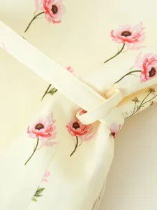 Détail en gros plan de l'imprimé floral anémone rose et du passant de ceinture sur blazer