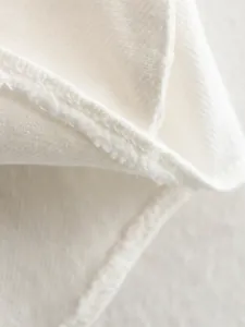 Detailed macro view showing the high-quality white faux denim fabric and neat stitching