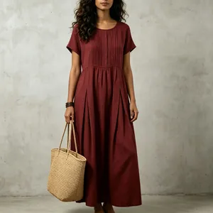 Detail view of the pleated front and texture of a burgundy cotton-linen maxi dress