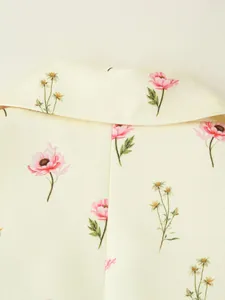 Gros plan de l'imprimé floral rose sur le tissu crème d'un blazer à la mode pour femme