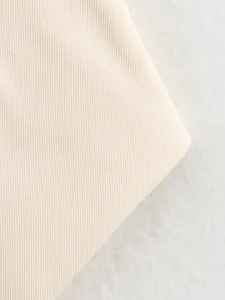 Macro view of structured beige twill fabric detail for spring/autumn women's vest