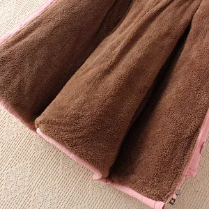 Nahaufnahme des weichen braunen Kunstfellfutters in einem warmen rosa Wintermantel