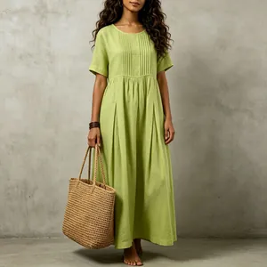 Close-up detail of a light green cotton linen maxi dress featuring elegant front pleats