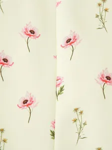 Gros plan détaillé montrant l'élégant imprimé floral rose et jaune sur le tissu du blazer crème