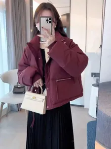Modell trägt eine kurze bordeauxrote Steppjacke mit Stehkragen in einem Spiegelselfie