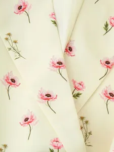 Vue macro détaillée de l'imprimé floral anémone rose sur un tissu de blazer crème