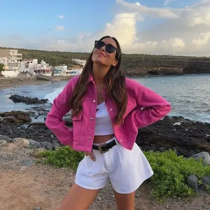 Giacca a camicia casual in lana rosa per donna in un ambiente costiero all'aperto