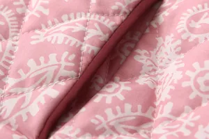 Detailed macro shot of pink paisley print quilted fabric with diamond stitching