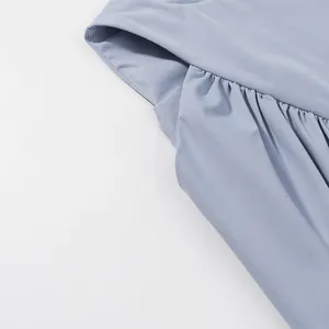 Close-up detail of the delicate pleated smocking on a light blue sleeveless summer top