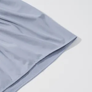 Detail view of light blue pleated sleeveless tank top showing hemline and fabric texture
