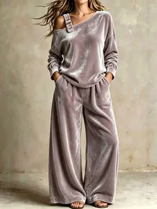 Detail des mauvefarbenen Samt-Off-Shoulder-Sets mit Schnallenriemen und weiter Hose