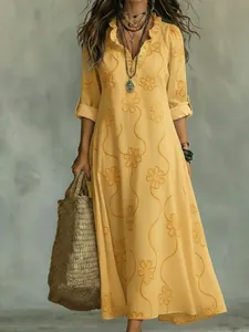 Detail of yellow bohemian dress with orange 3D flower print and ruffled V-neckline.