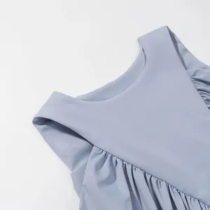 Close-up of a light blue sleeveless top with elegant pleats and a refined neckline detail.