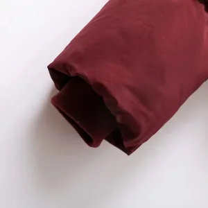Nahaufnahme der winddichten Rippbündchen an einer burgunderroten Wintersteppjacke