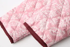 Close-up detail showing the quilted texture and pink paisley print of the jacket