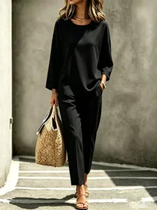 Stylish black long-sleeved two-piece set shown on model in urban street background