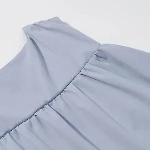 Detailed close-up view of the fine pleated stitching on a minimalist light blue sleeveless top