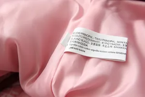 Close-up of pink quilted cotton jacket lining showing detailed wash care label
