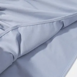 Macro detail of soft light blue fabric with precise stitching on a pleated sleeveless top