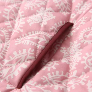 Close-up macro detail of pink quilted floral jacket featuring contrast burgundy pocket edge