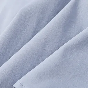 Macro view of light blue twill fabric texture showing soft pleats and weave detail