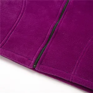Macro detailopname van de paarse fleece textuur en zwarte rits op het warme damesjack