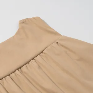 Detailed close-up showing the pleated texture and fabric of a beige sleeveless vest top