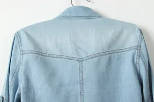 Gros plan détaillé de l'empiècement arrière et des coutures d'une chemise en jean bleu clair