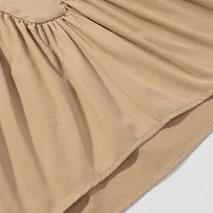 Close-up detail showing the pleated fabric of a beige sleeveless minimalist blouse