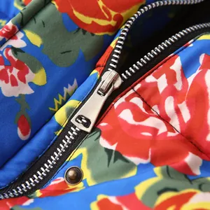 Macro detail of the durable silver metal zipper on a vibrant floral print quilted jacket
