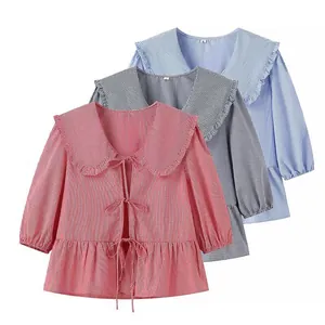 Detailed view of three gingham ruffed collar blouses in red blue and black