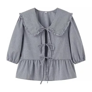 Detailed front view of black and white gingham blouse with doll collar and bow ties